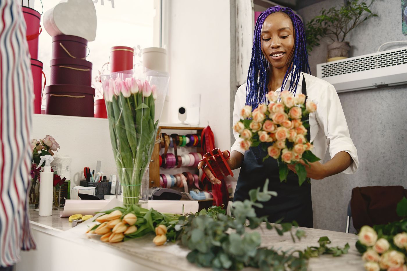 Fleuriste composant un bouquet de roses, Pétale & Cie