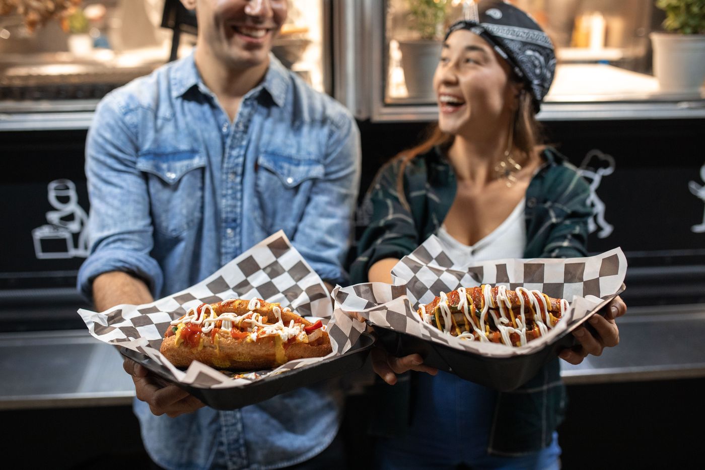 Clients dégustant des hot-dogs devant le camion La Braise Mobile