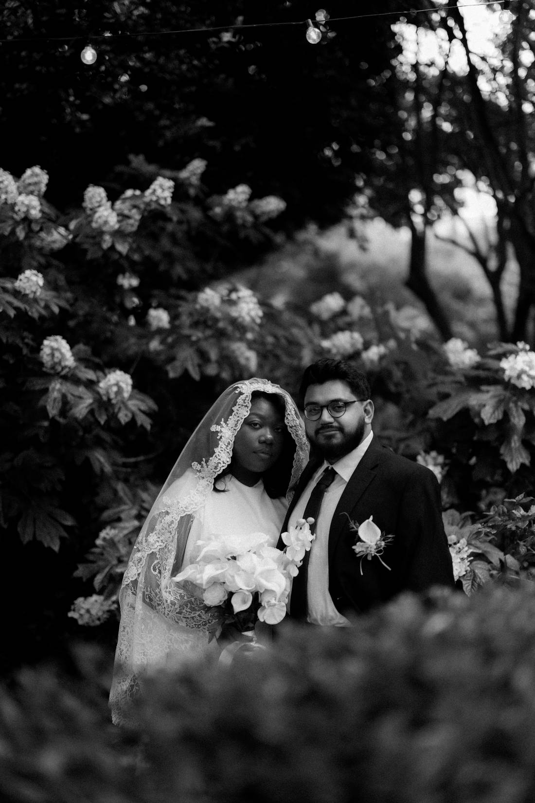 Portrait des mariés dans un jardin fleuri